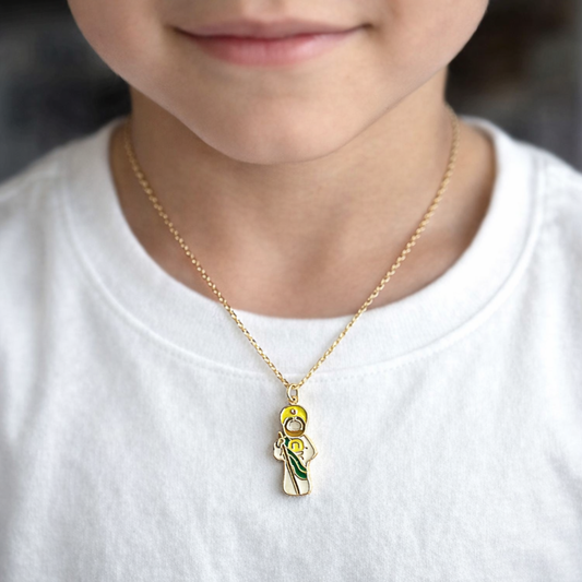 Child wearing a necklace with a pendant of Saint Jude on a plain background