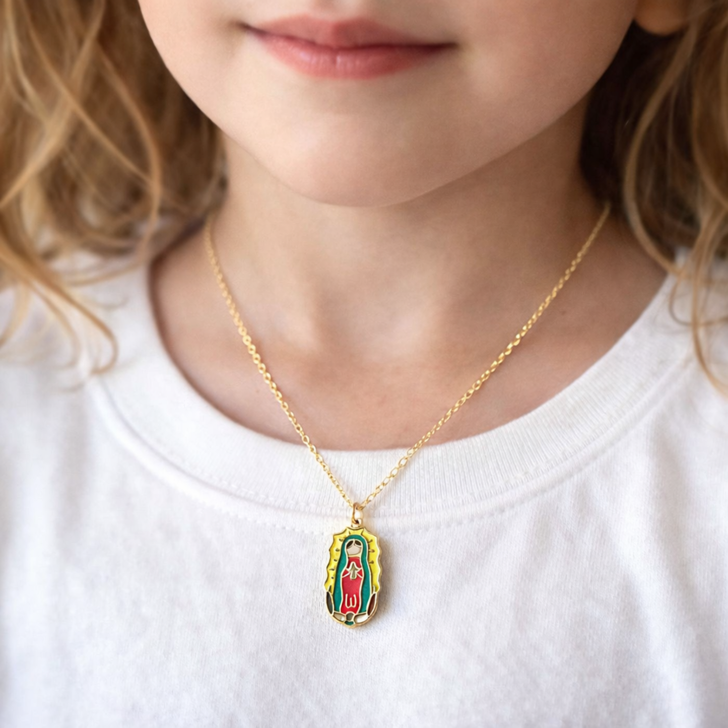 Child wearing a gold necklace with a Guadalupe pendant
