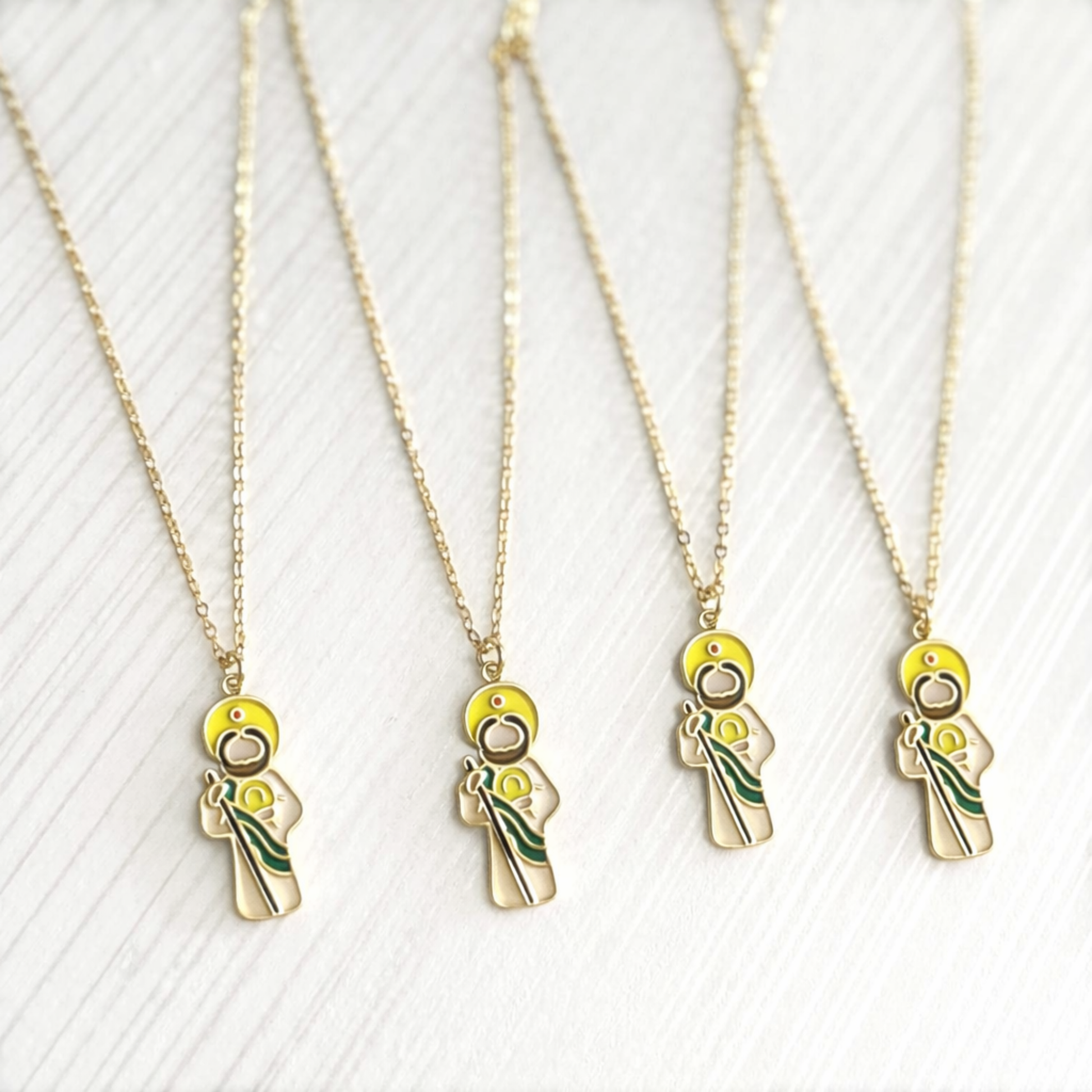 Gold necklaces with unique pendants of Saint Jude on a white background
