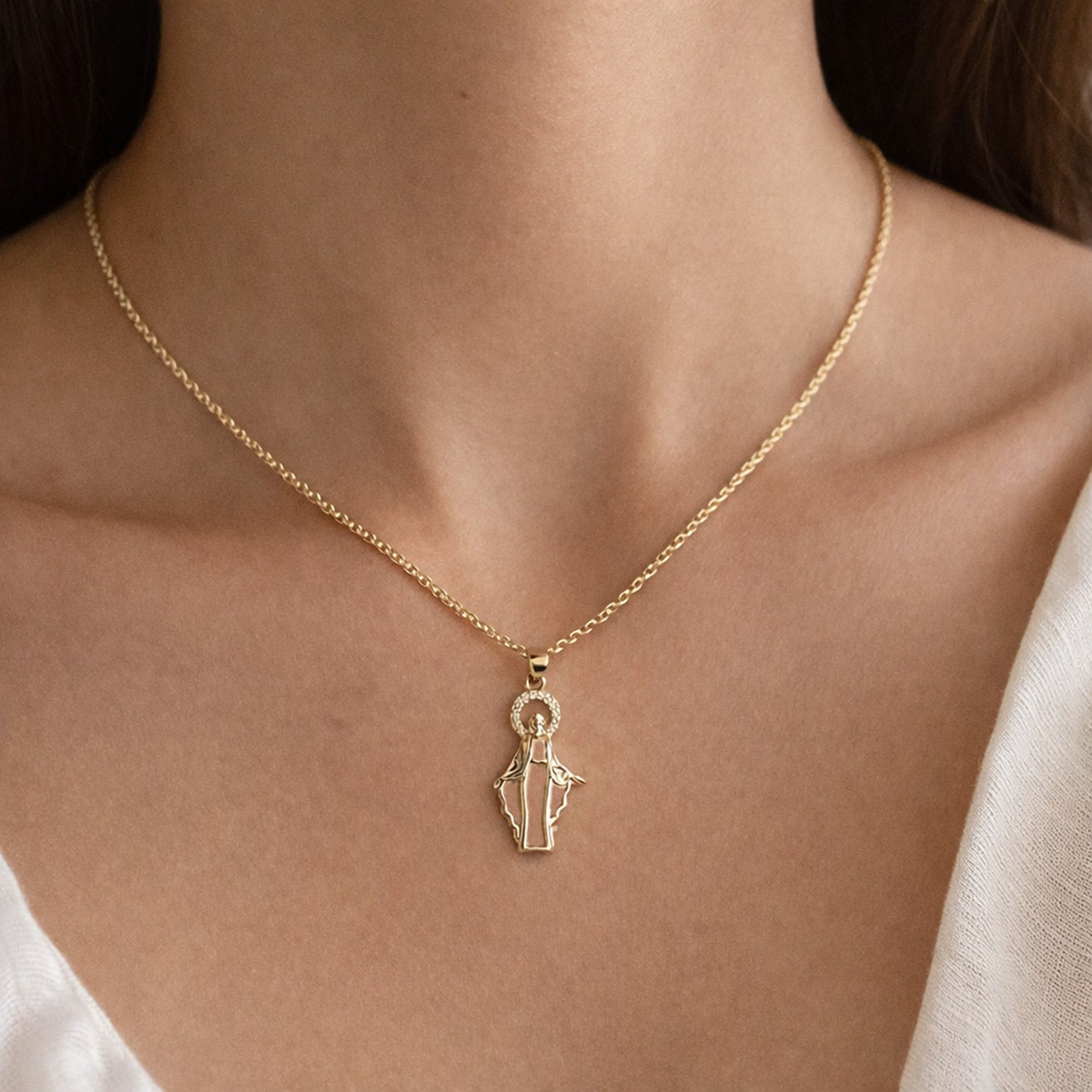 Gold necklace with a pendant on a person's neck