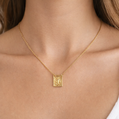 Gold necklace with a pendant of Saint Benedict on a person's neck