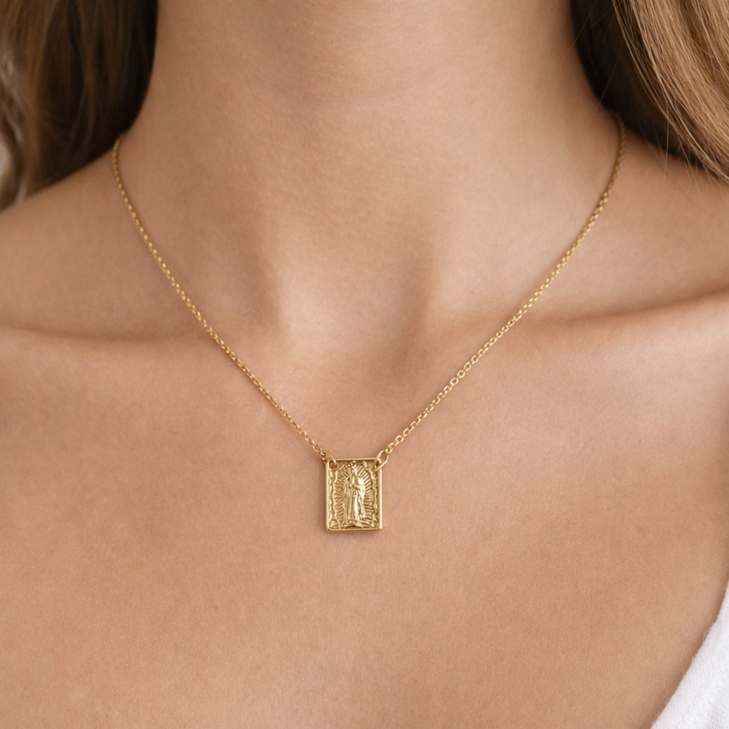 Gold necklace with a pendant on a person's neck