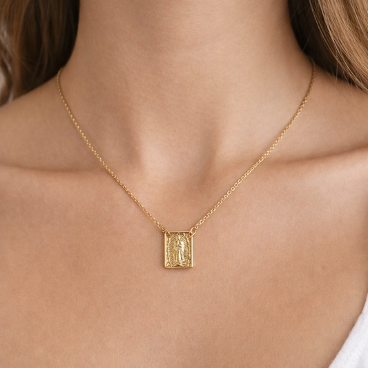 Gold necklace with a pendant on a person's neck
